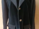 une veste bleu marine sur un cintre de mannequin accroché à un mur en bois