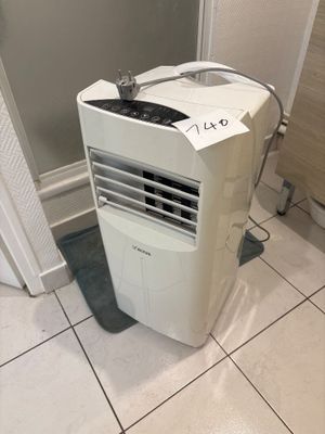 a small air conditioner sitting in the corner of a bathroom