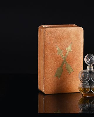 bottles of perfume on a black surface with a wooden box in the background
