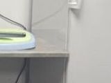 un seau bleu posé à côté d'un réfrigérateur blanc dans une pièce