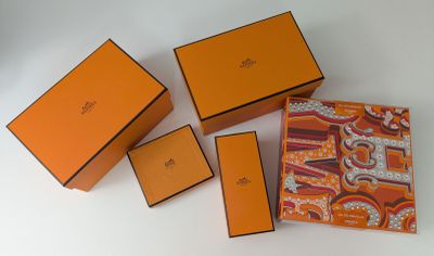 quatre boîtes orange et marron sont posées sur une surface blanche