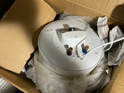 un détecteur de fumée blanc dans une boîte en carton posée par terre