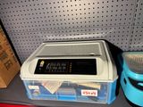 a plastic container with a lid on a shelf next to a plastic container with a lid on it
