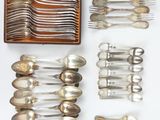 de nombreuses cuillères et fourchettes disposées sur une table
