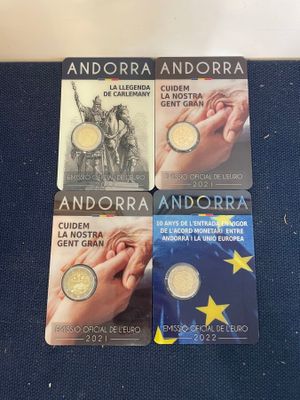 four commemorative coins are sitting on a blue surface