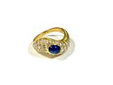 gros plan d'une bague en or avec une pierre bleue