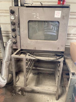 a silver oven sitting on a table in a garage