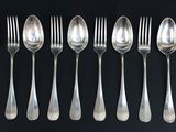 a set of six forks and spoons on a black background
