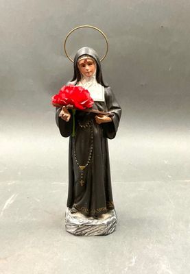 figurine représentant une religieuse tenant une rose rouge dans ses mains