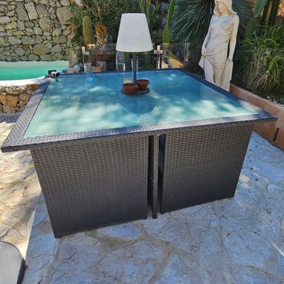 une table sur laquelle est posée une lampe, dans le jardin