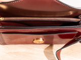 someone is holding a purse that is sitting on a table