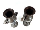 two silver vases sitting on top of each other