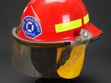 fireman ' s helmet with protective face shield on a black background
