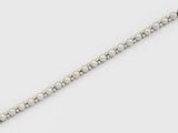 gros plan d'un bracelet avec des perles sur une surface blanche