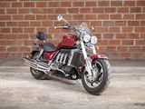 a red motorcycle that is parked in front of a brick wall
