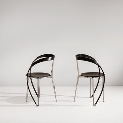 a pair of black chairs sitting on top of a white floor