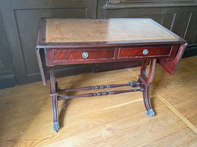 a small table with a drawer on it on a wooden floor