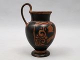 a black and brown vase with a design on it