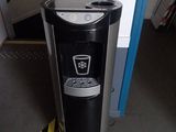 a black and silver water dispenser in the corner of a room