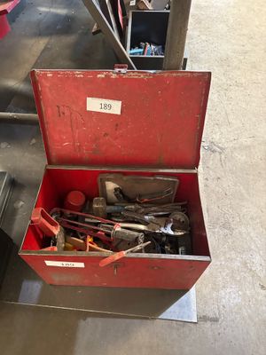 a red tool box with tools in it on the floor