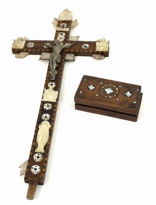 une croix en bois ornée de crânes et de croix, posée à côté d'une boîte en bois
