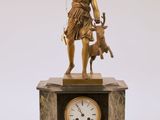 une statue représentant une femme tenant un chien et une horloge