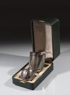 une tasse en argent et une cuillère en argent dans une boîte noire