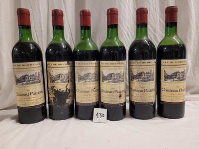 six bottles of red wine are lined up on a table