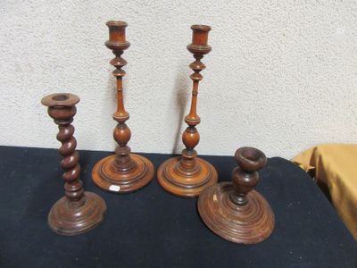 three wooden candlesticks sitting on a black table