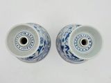 two blue and white vases sitting on a white surface