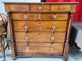 une commode en bois dans une pièce avec un rideau rouge
