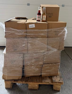 a stack of boxes on a pallet with a bottle of alcohol