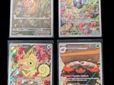 quatre cartes de pokémon différentes sont affichées sur une surface noire