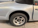 a silver car with a black top parked in a parking lot