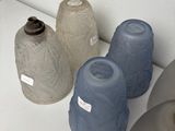 four vases sitting on a white table with labels on them