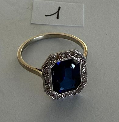 an image of a ring with a blue stone surrounded by diamonds