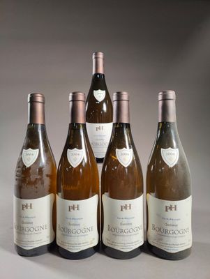 six bouteilles de vin sont alignées sur une table