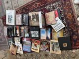 beaucoup de livres posés sur un tapis, par terre