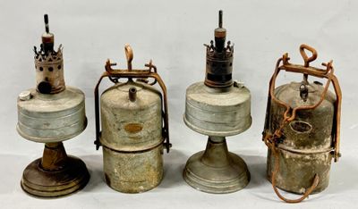 three old fashioned gas bottles are lined up on a white surface