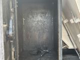an image of a garbage truck with its door open