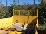 a yellow truck that is parked next to a fence