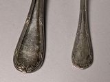 two spoons and a fork sitting on a table