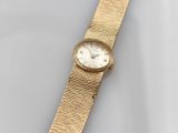 a close up of a gold watch on a white surface