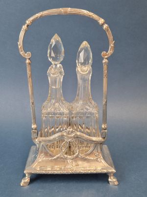 two crystal decanters sitting on a silver stand