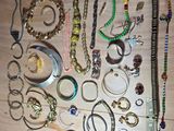 many different types of bracelets and necklaces laid out on a table