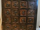 a wooden cabinet that has many drawers on top of it