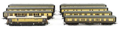several yellow and black train cars sitting next to each other on a white surface