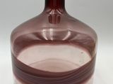 a purple glass vase with a red stripe on it