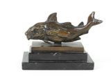statue représentant un poisson posée sur un socle en marbre, sur fond blanc