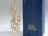 an image of a silver sculpture next to a blue box